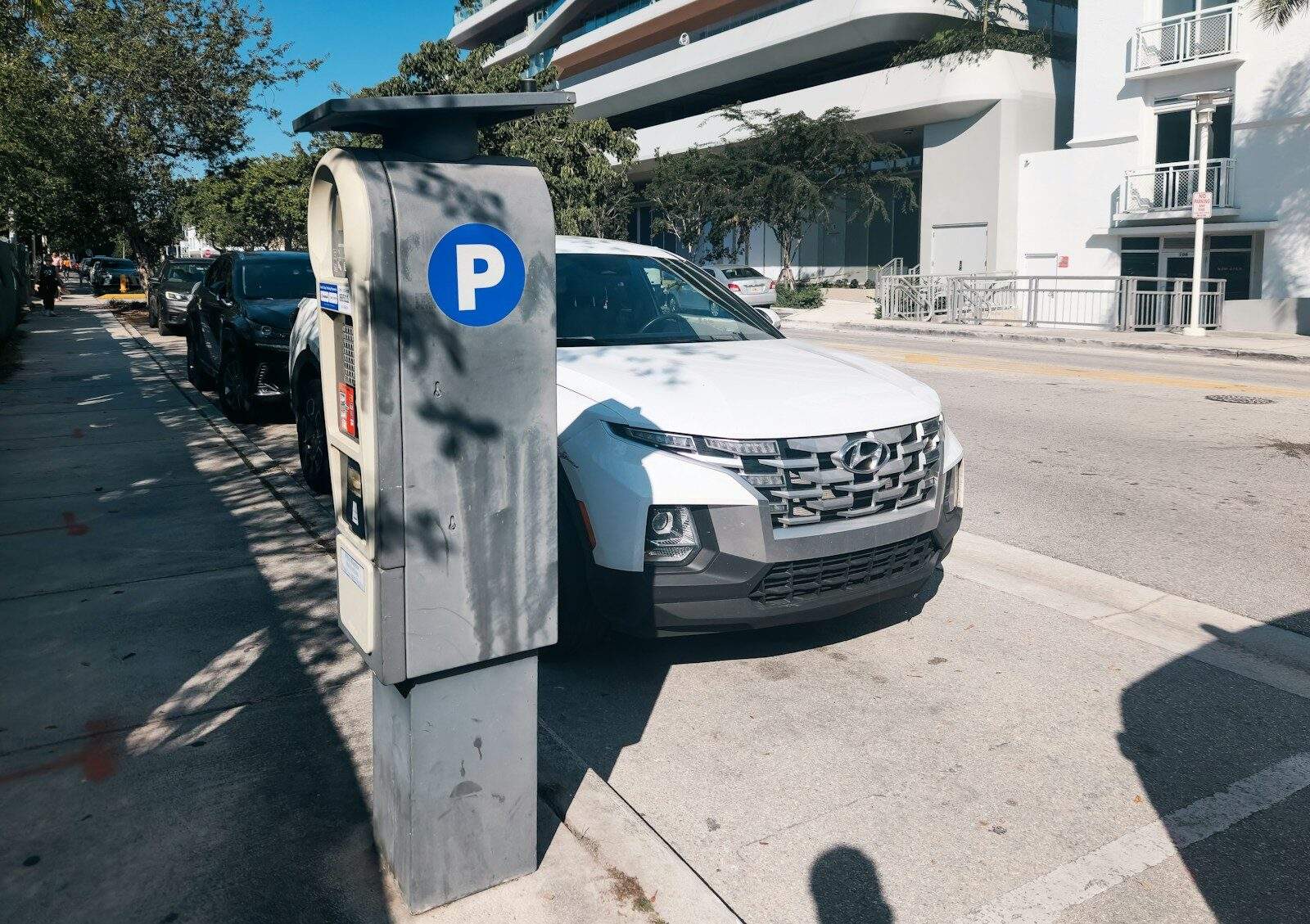 A car parked on the side of a street next to a parking meter