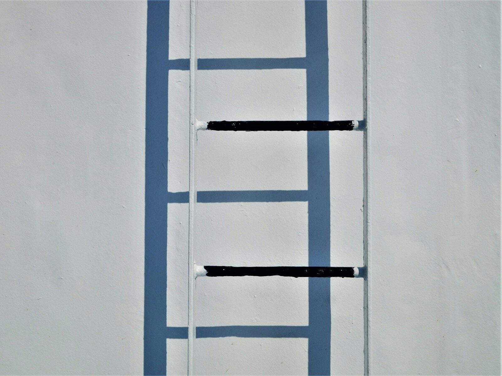 a ladder leaning up against a white wall